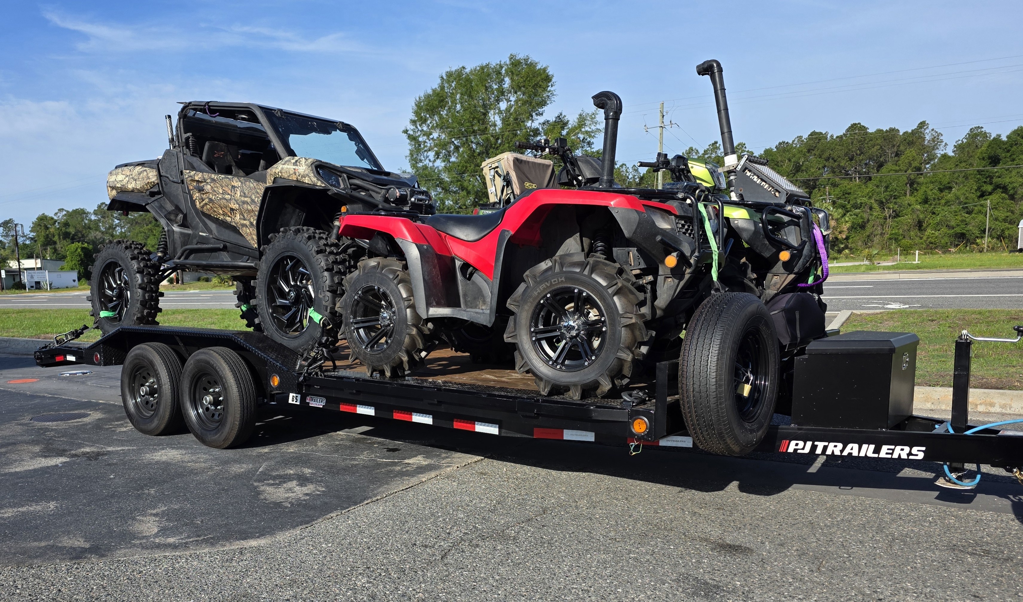 PJ Trailers car hauler loaded with ATVs and UTVs — available for rent at Yulee Trailer Rentals in Yulee, FL